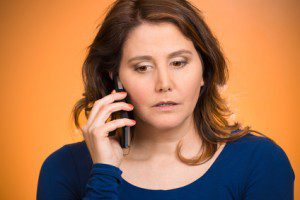 Sad stressed hopeless woman talking on mobile phone