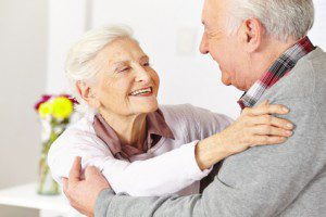 Two senior citizens dancing and smiling