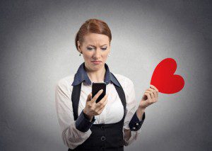 displeased woman reading news on phone throwing away heart