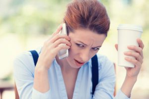 Closeup portrait upset sad, skeptical, unhappy, serious woman talking on phone, it doesn't sound good, sitting outside office. Negative human emotion facial expression, feeling life reaction. Bad news