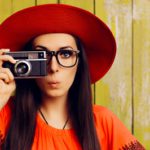 Frau mit Hut und Fotoapparat