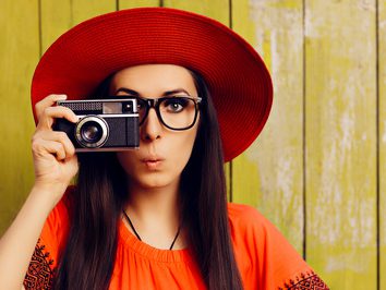 Frau mit Hut und Fotoapparat