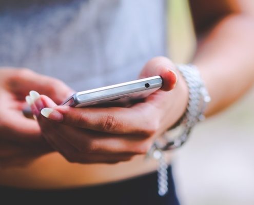 Frau hält Handy in Hand