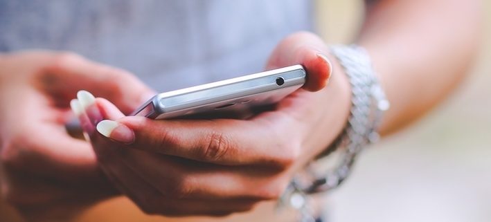 Frau hält Handy in Hand