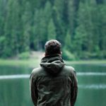 Mann sitzt am See