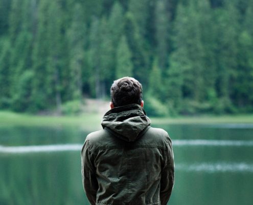 Mann sitzt am See