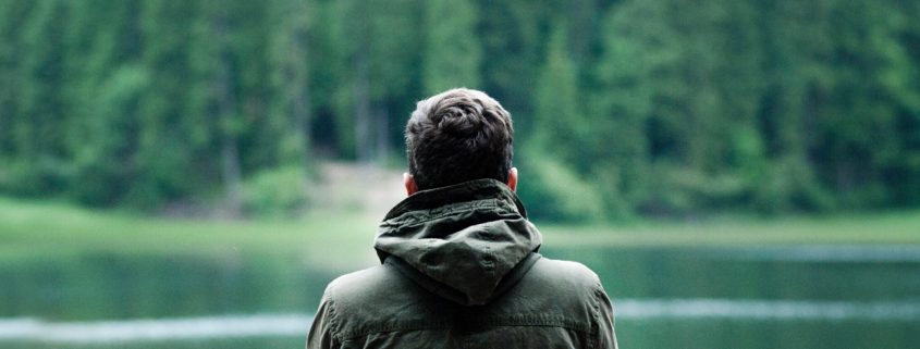 Mann sitzt am See