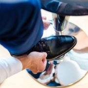 Mann mit Schuh auf Hocker