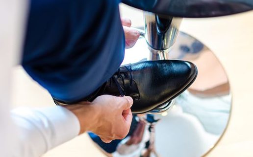 Mann mit Schuh auf Hocker